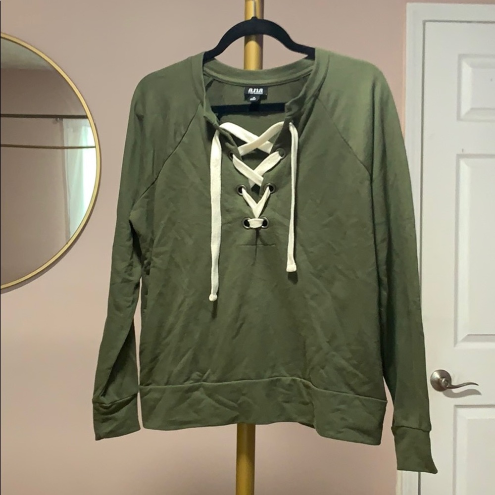 green sweater with white ties in the front